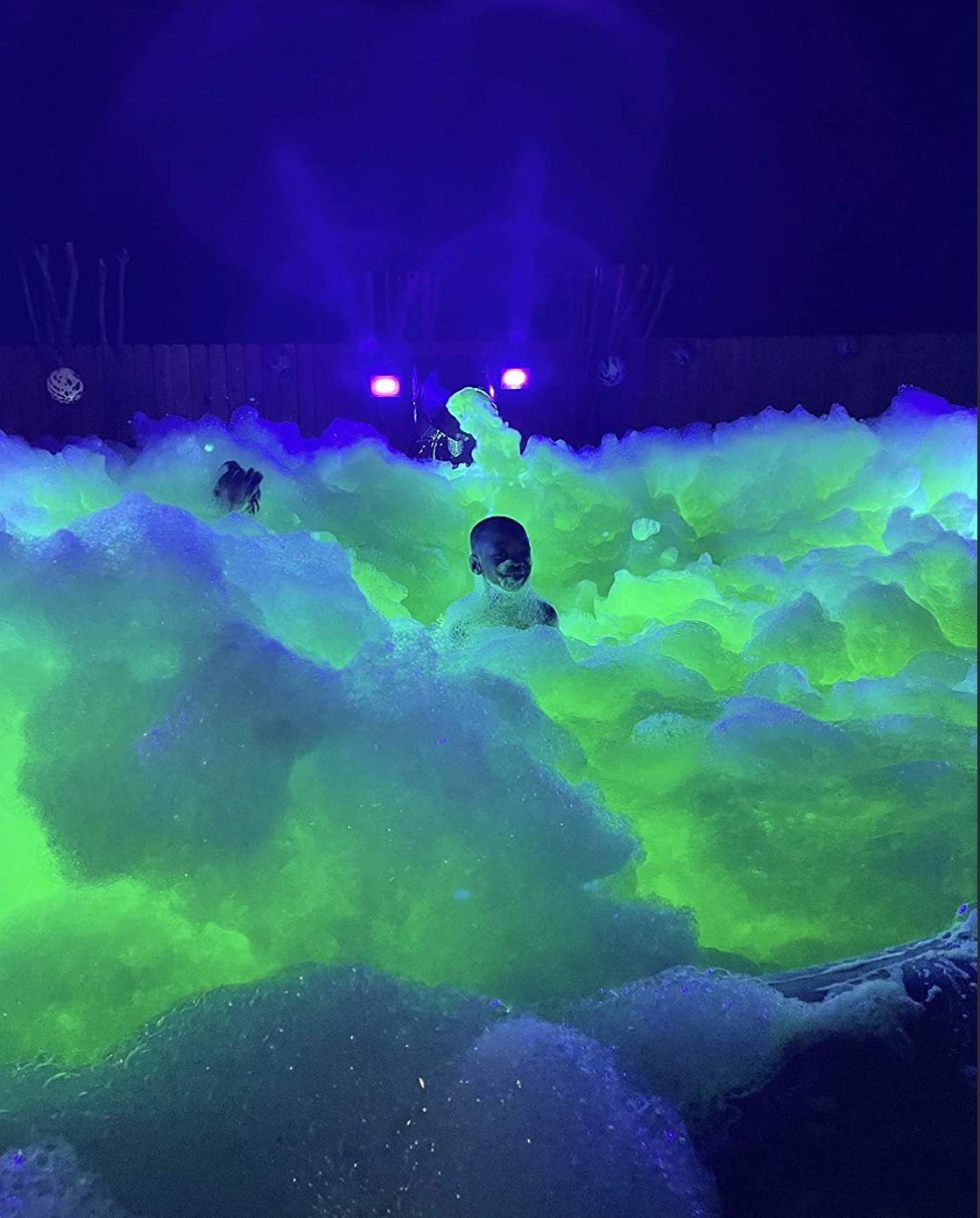 Glowing green and blue foam at a backyard night party